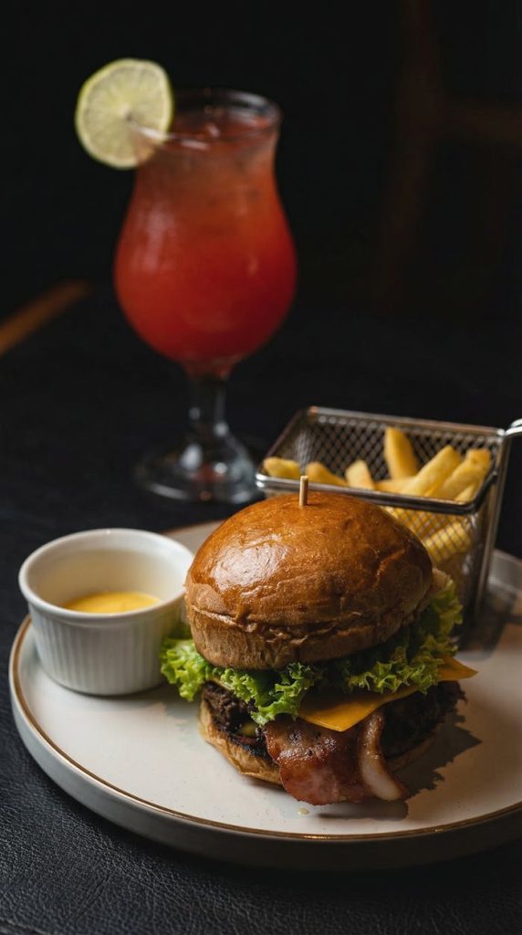 Delicious Colombian burger with fries and cocktail, perfect for a gourmet meal.
