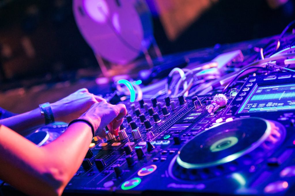 DJ uses a digital mixer to create music at a lively nightclub event.