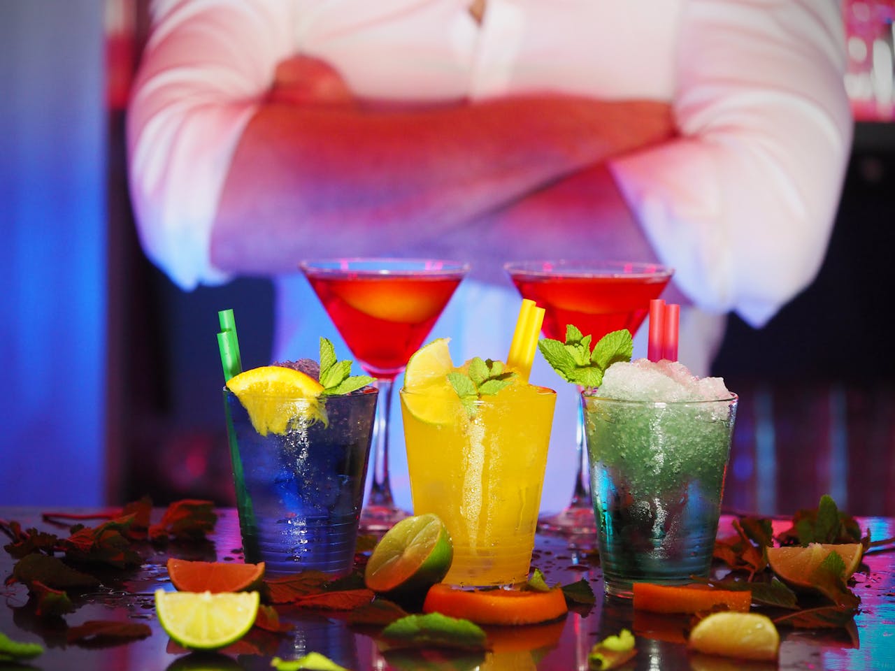 Colorful cocktails with citrus slices on a bar, perfect for nightlife settings.
