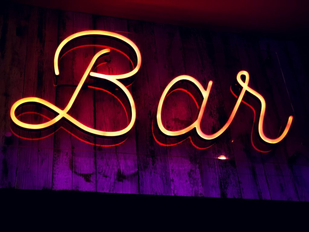 A neon bar sign, illuminated outside a pub in the U.K.